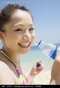 沙滩上拿着水瓶微笑的比基尼美女图片免费下载 编号1149975 红动网 